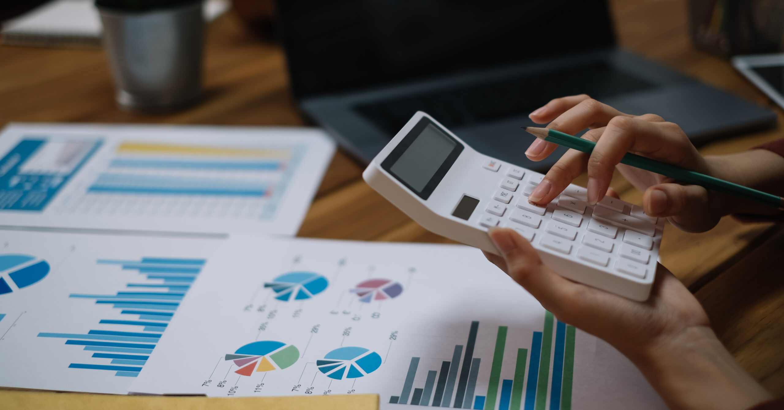 Close up Business woman using calculator and laptop for do math finance tax, accounting, statistics research concept